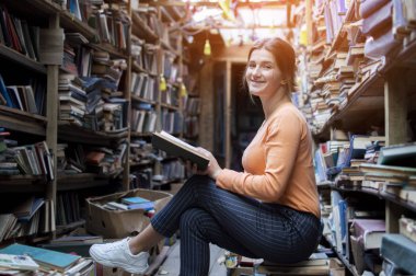 kız öğrenci kütüphanede bir kitap okur, bir kadın çok okumayı seviyor, o kitapraflarında edebiyat arıyor, bilgi güç, kavram