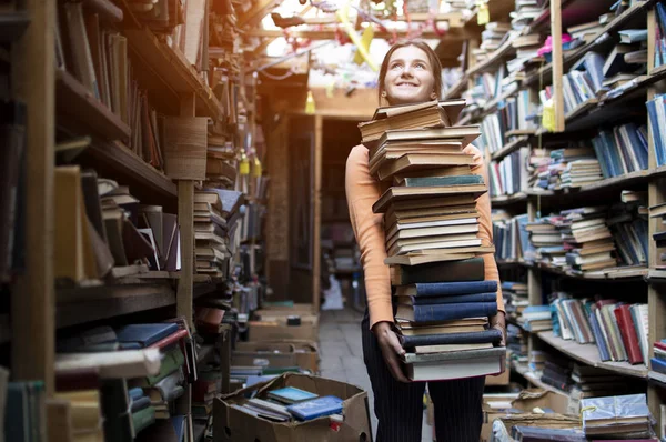 kız öğrenci kütüphanede kitap büyük bir yığın taşır, çalışma için hazırlık, bilgi güç, kavram