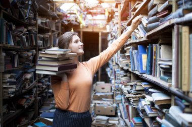 kız öğrenci eski kütüphanede edebiyat arıyor, o kitaplık bir kitap alır, bir kadın arşivlerde bilgi arıyor