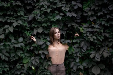 genç kız doğa ile tek başına yeşil yaprakları duruyor, bir kadın bitkiler ve rüyalar, doğada bir erkek kavramı dokunur