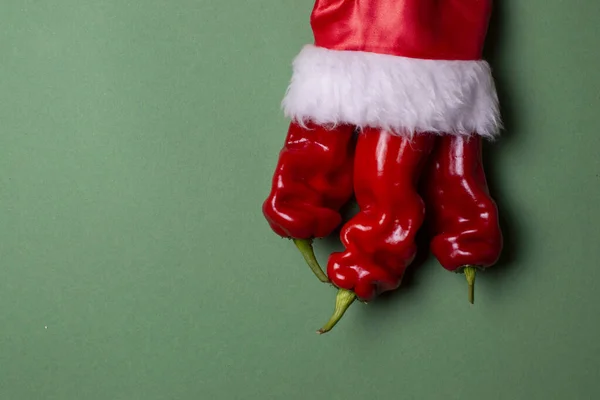 Pimienta de Año Nuevo sobre un fondo verde, productos de mesa de Navidad, pimiento picante en traje de santa —  Fotos de Stock