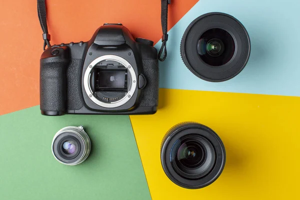 SLR camera with a set of different lenses on a colored background, the choice of device for the camera concept