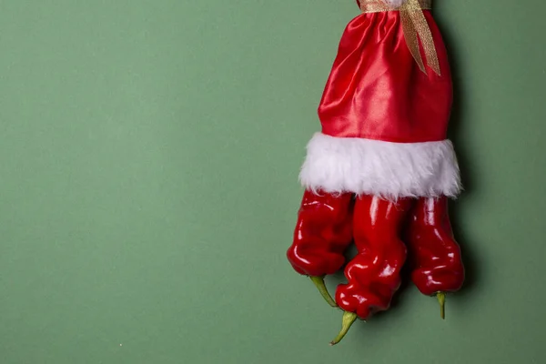 Pimienta de Año Nuevo sobre un fondo verde, productos de mesa de Navidad, pimiento picante en traje de santa —  Fotos de Stock