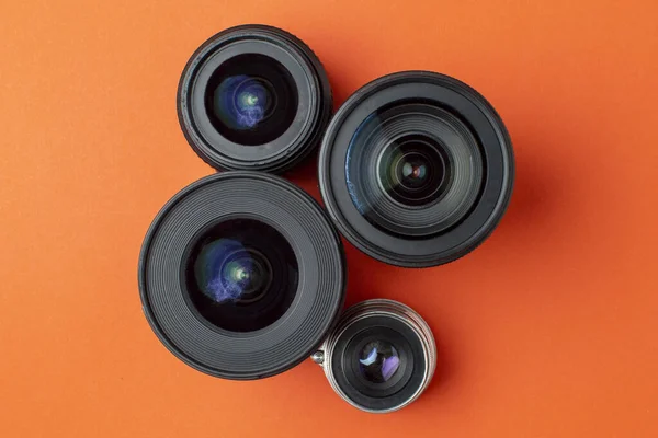 Progress of different photo lenses on a colored background, a set of old and modern photo devices for the camera — Stock Photo, Image