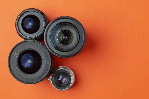 Progresso de lentes de foto diferentes em um fundo colorido, grupo de dispositivos de foto velhos e modernos da câmera — Fotografia de Stock