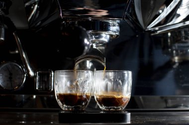Kahve makinesi geceleri bardakta duble espresso yapıyor. Kahve yapma süreci, yakın plan.