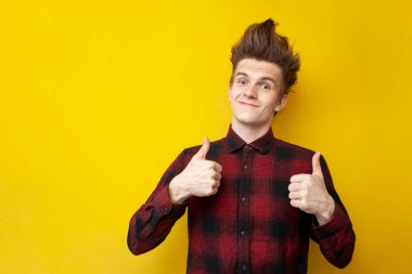 Komik saç stili olan genç adam sarı izole bir arka planda, kendine güler yüzlü, güçlü saç stili olan, kopyalama alanı olan, kendine güvenen bir adam.