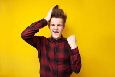 Genç adam bir saç stiline dokunur ve mutludur, güçlü bir saç stili, iyi bir saç bakım konsepti olan bir adam.