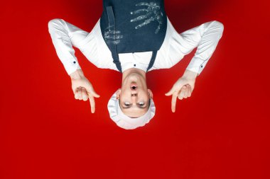 Genç aşçı kırmızı izole arka plandaki kopyalama alanına bakar. Şef üniformalı adam mesaj için reklam verir.