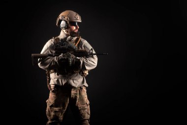 Askeri üniformalı özel kuvvetlerin gece vakti silahlı portresi. Seçkin birlikler görev başında. Karanlık bir geçmişe karşı teröristler.