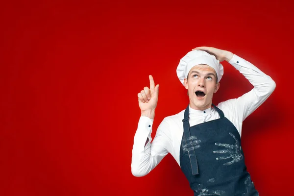年轻的震惊厨师在红色孤立的背景上展示了复制空间 震惊了身着制服广告的厨房工作人员 — 图库照片