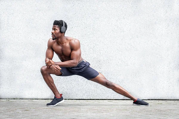 Afrika kökenli Amerikalı sporcu, dışarıda duvara karşı spor yapıyor, sporcu ısınıyor, sağlıklı yaşam tarzı konsepti yapıyor, uzayı kopyalıyor.