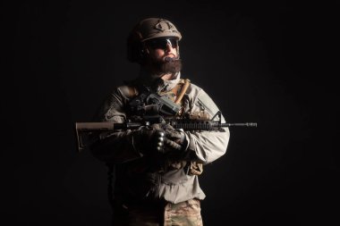 Askeri üniformalı özel kuvvetlerin gece vakti silahlı portresi. Seçkin birlikler görev başında. Karanlık bir geçmişe karşı teröristler.