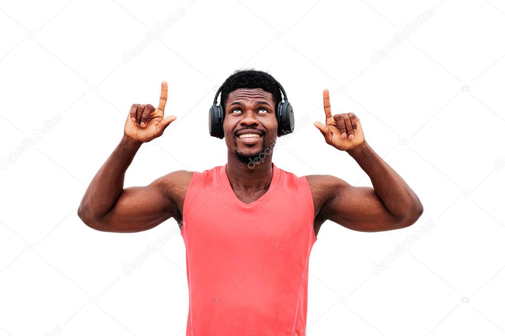 african american sports guy listens to music on headphones and shows with his hands up on a white isolated background, man advertises copy space
