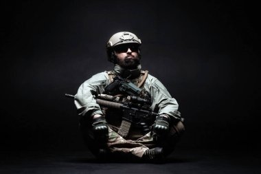 Amerikan askeri üniformalı, karanlık bir arkaplanda oturan Amerikan askeri. Amerika 'nın seçkin askerleri, Amerikan özel kuvvetleri.