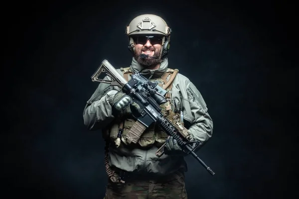 身穿军械 手持来复枪的士兵在夜里笑着 身着制服的突击队员面对着漆黑的黑色背景 一个护林员的画像 — 图库照片