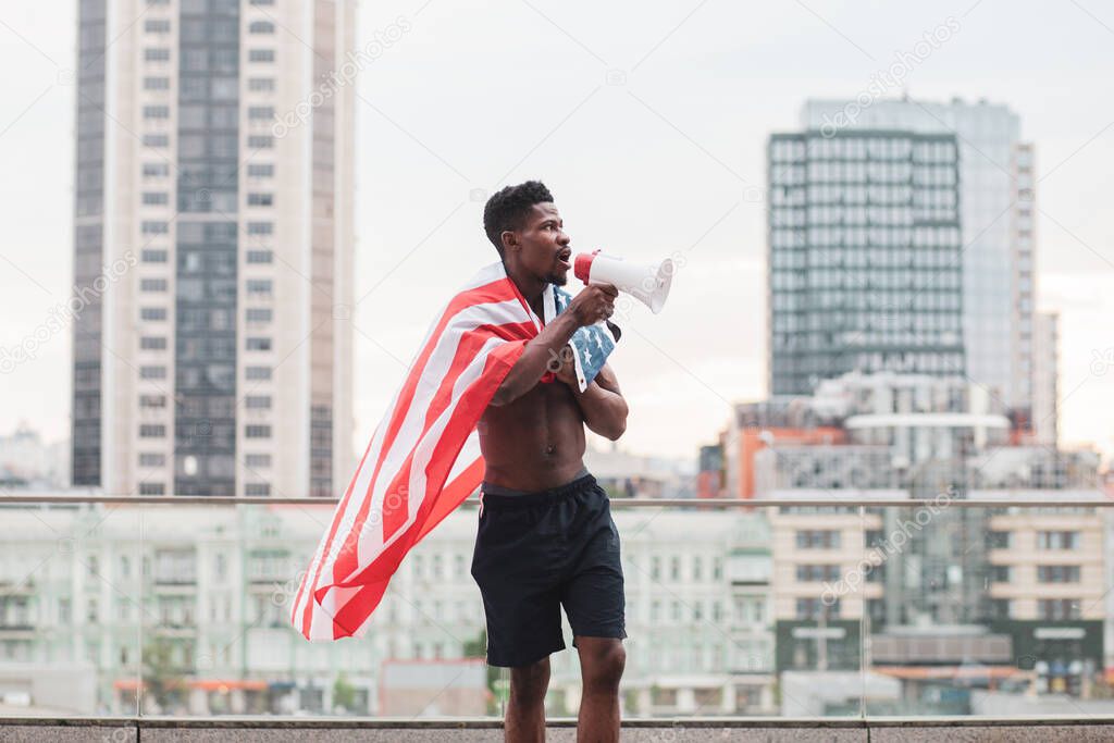 black lives matter concept. Aggressive african american guy with usa flag protests and shouts, patriot activist of america makes rebellion, copy space