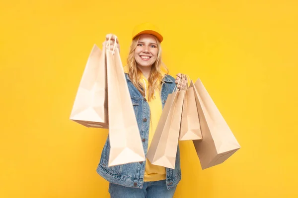 Joven Chica Sosteniendo Bolsas Compras Sobre Fondo Amarillo Sonriente Hipster — Foto de Stock