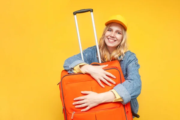 Happy Young Girl Tourist Hugs Suitcase Smiles Yellow Isolated Background — Stock Photo, Image