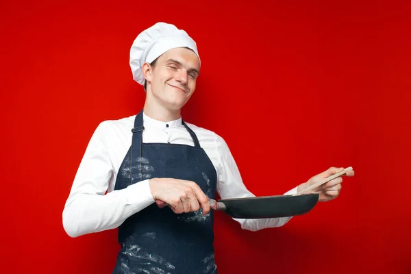 Jovem Chef Surpreso Detém Pratos Prepara Prato Fundo Isolado Vermelho — Fotografia de Stock