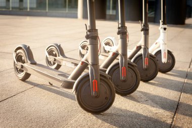 Elektrikli scooterlar şehrin arka planında, geleceğin ulaşımında, çevre taşımacılığında, yakın planda dururlar.