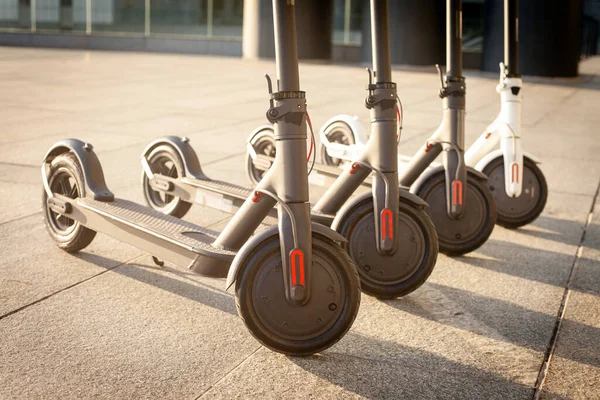 Elektrikli scooterlar şehrin arka planında, geleceğin ulaşımında, çevre taşımacılığında, yakın planda dururlar.
