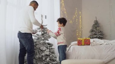 Yeni yılda oğluyla birlikte Afrika kökenli Amerikalı bir adam Noel ağacını oyuncaklarla süslüyor ve Noel 'i evde kutluyor. Babası çocuğun yeni yıl atmosferini hazırlamasına yardım ediyor.