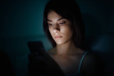 Smartphone gece yatakta kadınla