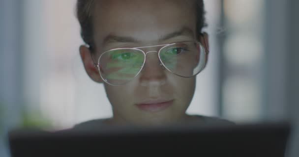 Υψηλής ποιότητας βίντεο 4K 12bit. Νέος εργαζόμενος στο γραφείο με γυαλιά που αφορούν ένα φορητό υπολογιστή, βρίσκοντας προβλήματα. βραδινή δουλειά. Η γυναίκα στον υπολογιστή ψάχνει για μια λύση στο πρόβλημα. — Αρχείο Βίντεο