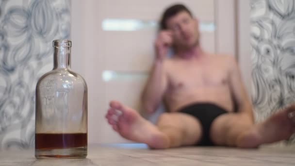 Młody Człowiek Pijany Śpi Podłodze Domu Obok Butelkę Whisky — Wideo stockowe