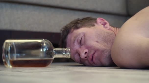 Seorang Pemuda Mabuk Tidur Lantai Rumah Sebelah Botol Wiski — Stok Video
