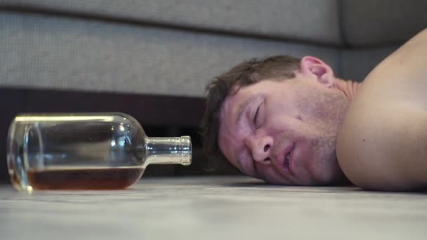 Ung Berusad Man Sover Golvet Huset Bredvid Flaska Whisky — Stockvideo