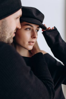 İki hipster modelleri: bir adam ve boş siyah t-shirt, kot pantolon ve poz bir kadın. siyah şapka, şapka, aşk, öpücük