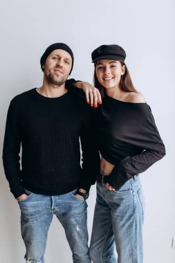 İki hipster modelleri: bir adam ve boş siyah t-shirt, kot pantolon ve poz bir kadın. siyah şapka, şapka, aşk, öpücük