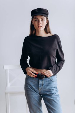 Siyah şapkası, siyah golf, mavi kot pantolon güzel kız! Doğal ışık, akıllı casua, sokak casual