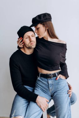 İki hipster modelleri: bir adam ve boş siyah t-shirt, kot pantolon ve poz bir kadın. siyah şapka, şapka, aşk, öpücük
