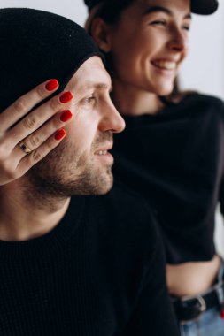 İki hipster modelleri: bir adam ve boş siyah t-shirt, kot pantolon ve poz bir kadın. siyah şapka, şapka, aşk, öpücük