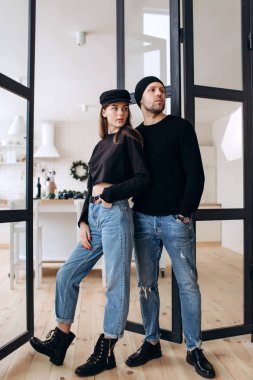 İki hipster modelleri: bir adam ve boş siyah t-shirt, kot pantolon ve poz bir kadın. siyah şapka, şapka, aşk, öpücük