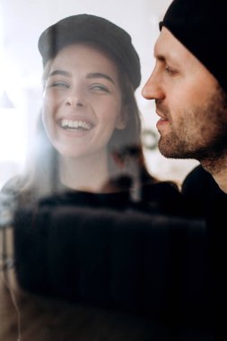 İki hipster modelleri: bir adam ve boş siyah t-shirt, kot pantolon ve poz bir kadın. siyah şapka, şapka, aşk, öpücük