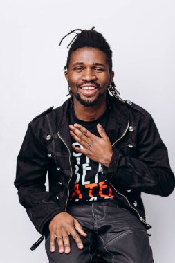 Bir çekici gülümseyen siyah adam siyah ceket ve gri arka plan üzerinde siyah pantolon