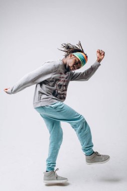 Bir gri kazak ve mavi pantolon gri bir arka plan üzerine siyah bir gülümseyen portre genç modeli