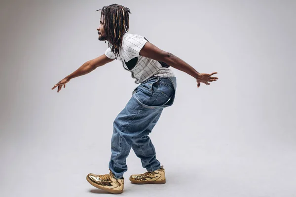 African American on a white background in jeans and a white T-shirt, emotions, emotional person