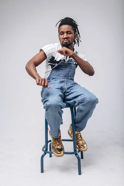 African American on a white background in jeans and a white T-shirt, emotions, emotional person