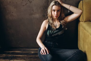 Bir güzel moda kadın, Sarışın, kot pantolon, kahverengi arka plan portresi