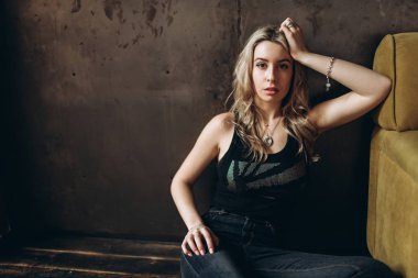 Bir güzel moda kadın, Sarışın, kot pantolon, kahverengi arka plan portresi