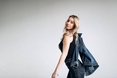 Güzel moda kadın, Sarışın, kot pantolon, gri arka plan portresi