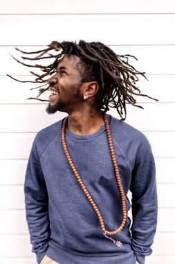 Güzel African American saç kahverengi pantolon ve evler, arka planı Mavi kazak uçan olan dreadlocks ve geliştirme, şehir