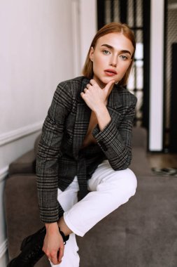 Güzel, tatlı bir kız, çıplak bir vücut ceketi giymiş. Kısa saçlı altın şık model, dolgun dudaklar, rahat giyim, kostüm, kıyafet. Model testi, giyim reklam