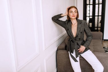 Güzel, tatlı bir kız, çıplak bir vücut ceketi giymiş. Kısa saçlı altın şık model, dolgun dudaklar, rahat giyim, kostüm, kıyafet. Model testi, giyim reklam
