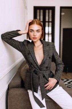Güzel, tatlı bir kız, çıplak bir vücut ceketi giymiş. Kısa saçlı altın şık model, dolgun dudaklar, rahat giyim, kostüm, kıyafet. Model testi, giyim reklam